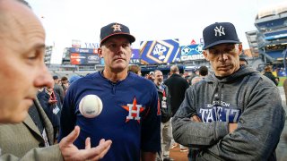 New York Yankees general manager Brian Cashman talks to manager Joe Girardi and Houston Astros manager A.J. Hinch before Game 3 of baseball’s American League Championship Series Monday, Oct. 16, 2017, in New York. (AP Photo/Kathy Willens)