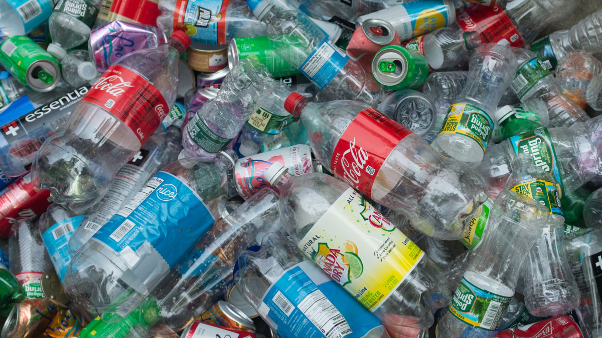 A large pile of plastic bottles and cans collected on a street corner in downtown Manhattan, New York.