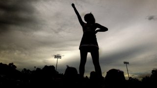 A cheerleader in silhouette