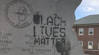 The phrase "Black Lives Matter" is painted on a Delaware State Police memorial.