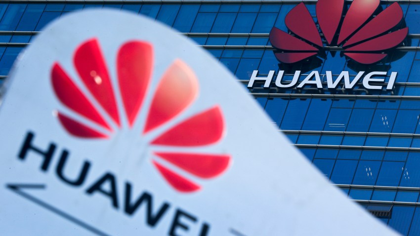 FILE - This Tuesday, Dec. 18, 2018, file photo, shows company signage on display near the Huawei office building at its research and development center in Dongguan, in south China's Guangdong province.