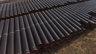 In this aerial view steel pipes lie stacked ahead of construction of a natural gas pipeline