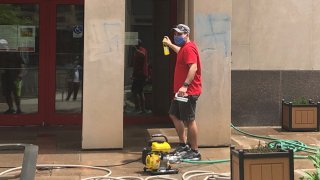 A man attempts to scrub away swastikas that were spray painted on an American Red Cross building in Philadelphia.