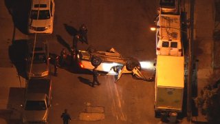 Police surround an overturned car after it crashed following a fatal shooting in Southwest Philadelphia.