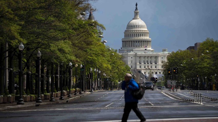 In this April 13, 2020, file photo, a pedestrian crosses a street past the U.S. Capitol in Washington, D.C.