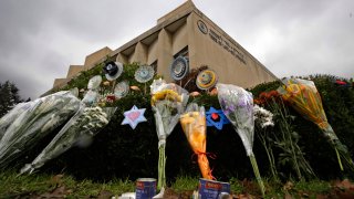 a makeshift memorial of flowers rests on bushes outside the Tree of Life Synagogue in Pittsburgh.