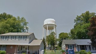white water tower, trees and homes