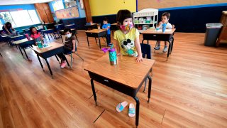 In this July 9, 2020, file photo, children in a pre-school class wear masks and sit at desks spaced apart as per coronavirus guidelines during summer school sessions in Monterey Park, California.