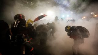 Federal officers launch tear gas at a group of demonstrators during a Black Lives Matter protest at the Mark O. Hatfield United States Courthouse Sunday, July 26, 2020, in Portland, Ore.