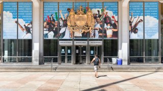A man walks toward Philadelphia's Municipal Services Building, where a mural depicts people raising their fists in the air as a tribute to the Black Lives Matter movement.