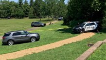 Police SUVs park at Fischer's Park in Montgomery County, Pennsylvania, as crime scene tape surrounds a grassy area.