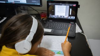 A student attends an online class from home in an arranged photograph