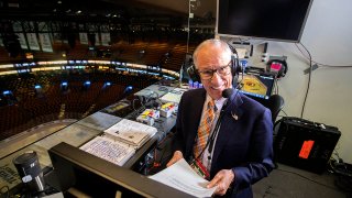 In this May 27, 2019, file photo, hours before Game 1 of the Stanley Cup Finals between the Boston Bruins and the St. Louis Blues at TD Garden in Boston, NBC hockey play-by-play announcer Mike Emrick does voice overs in the empty arena.