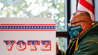 In this Oct. 20, 2020, file photo, a man casts his ballot at Tippecanoe Library on the first day of in-person early voting for the November 3rd elections in Milwaukee, Wisconsin.