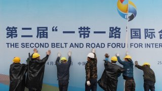 Workers take down a Belt and Road Forum panel outside the venue of the forum in Beijing on April 27, 2019.