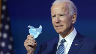 U.S. President-elect Joe Biden holds a protective mask as he speaks to the media after receiving a briefing from the transition COVID-19 advisory board on November 09, 2020.