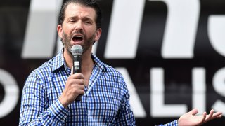 Donald Trump Jr speaks during a rain shower to an audience wearing ponchos at a Fighters Against Socialism campaign rally in support of his father, U.S. President Donald Trump.