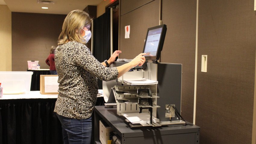 An election worker in Berks County loads mailed ballots into a pre-canvass scanner. Counties in Pennsylvania are not allowed to count mailed ballots until Nov. 4, but they can open envelopes and get ballots ready for the count.