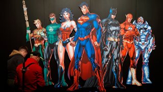 In this April 26, 2018, file photo, a DC Comics universe poster of Batman, Superman, Wonder Woman, The Joker, The Flash and others is displayed during the press preview of the exhibition "The Art of the Brick: DC Super Heroes" at Parc de la Villette in Paris, France.