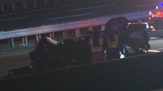 A car rests on its roof as emergency crews surround it after a crash on the New Jersey Turnpike.