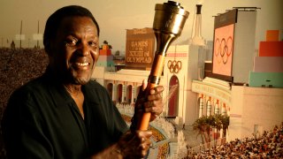 Former Olympic decathlete Rafer Johnson, 74, holds the same cauldron that he used to light the Olympic flame, located above the Los Angeles Memorial Coliseum, during the opening ceremony for the 1984 Olympic games in Los Angeles back on July 28, 2009. In background is a photograph that recorded that moment, located above dining room table of his home in Sherman Oaks on July 27, 2009.