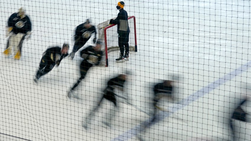 Boston Bruins players skate around a goal during a speed drill at the team's NHL hockey training camp, Monday, Jan. 4, 2021, in Boston.