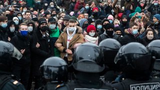 In this Jan. 23, 2021, file photo, people stand in front of police officers during a protest against the jailing of opposition leader Alexei Navalny in Moscow, Russia.