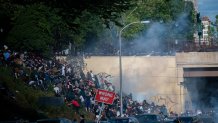 Protesters race up a hill after being shot by tear gas after a march through Center City on June 1, 2020 in Philadelphia, Pennsylvania.