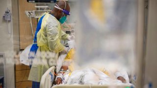 Nurses wearing personal protective equipment (PPE) attend to patients in a Covid-19 intensive care unit