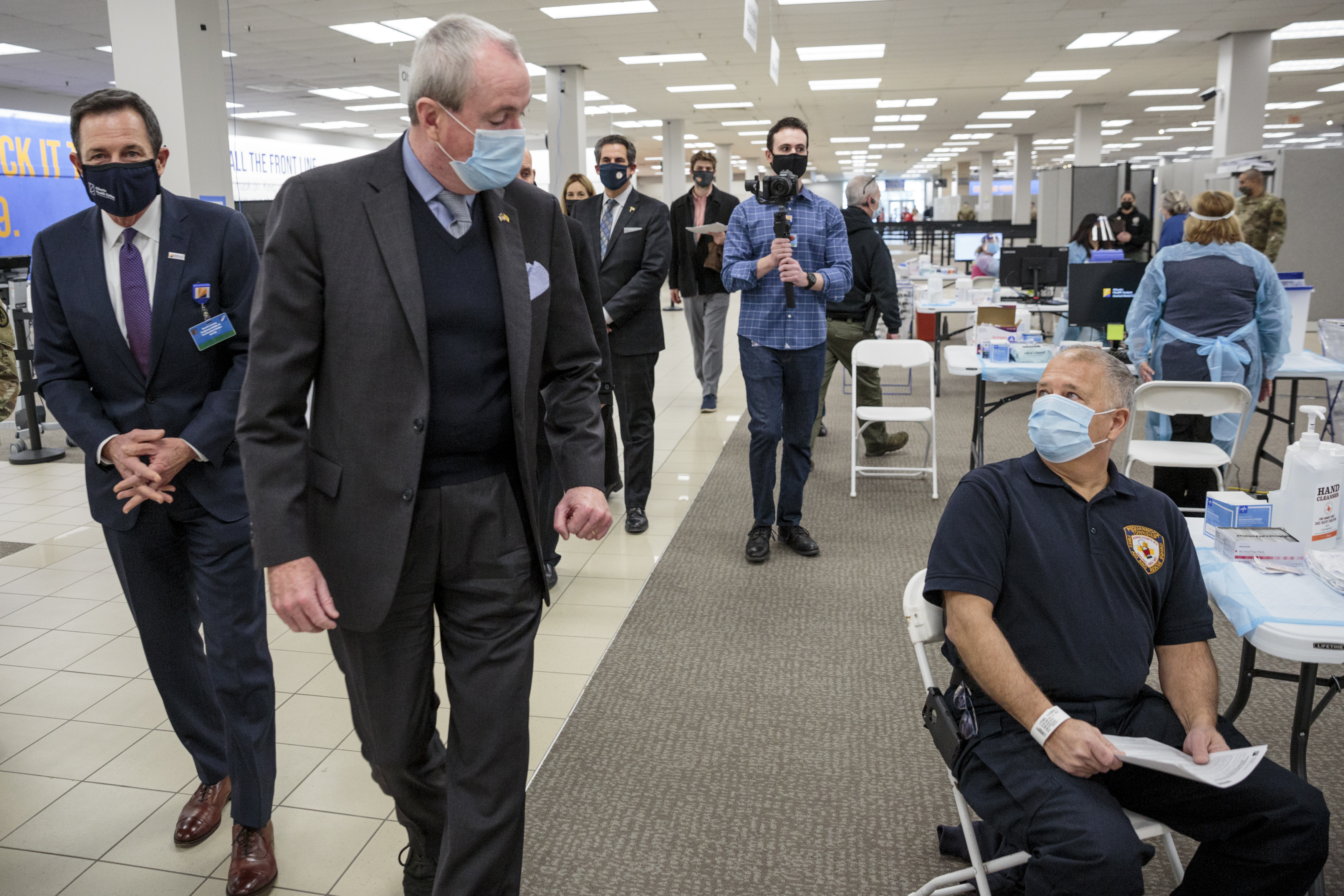 Phil Murphy, New Jersey's governor, second left, greets police sergeant during a tour of the Morris County Covid-19 vaccination site at the Townsquare Mall in Rockaway, New Jersey, U.S., on Friday, Jan. 8, 2021.
