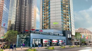 A rendering shows people walking down a sidewalk next to a brewery that sits in front of the former Embassy Suites Hotel, which is being converted into apartments in Philadelphia's Benjamin Franklin Parkway.