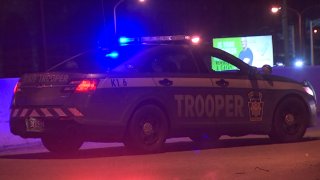 A Pennsylvania State Police Department cruiser flashes its lights as it parks near the scene of a shooting on Interstate 76 in Philadelphia.