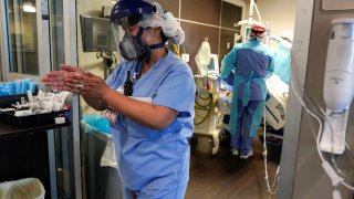 A nurse sanitizes her hands as she leaves a coronavirus disease (COVID-19) patients room in the ICU at SSM Health St. Anthony Hospital in Oklahoma City, Oklahoma, January 28, 2021.