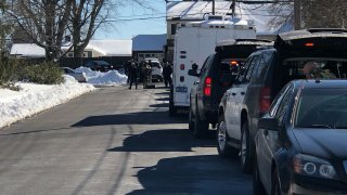 Police vehicles and officers are seen on a sunny day on a Chalfont, Pennsylvania, street