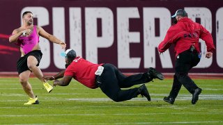 Security tries to grab a fan on the field during the second half of the NFL Super Bowl 55 game between the Tampa Bay Buccaneers and the Kansas City Chiefs, Feb. 7, 2021, in Tampa, Fla.