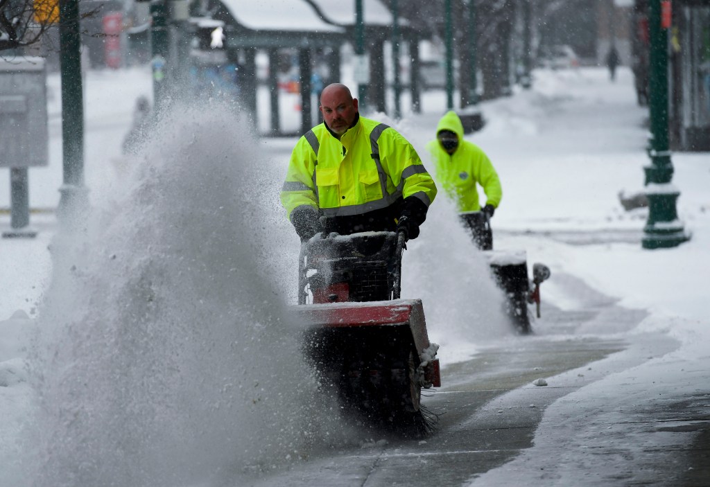 Man with snowblower pushes snow