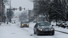 Cars make their way along a snow covered Penn Street in Reading, Pennsylvania