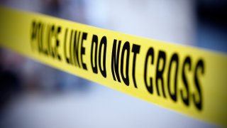Yellow police line tape on a grayish background