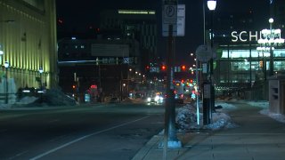 An empty street is shown next to a sidewalk in Center City. Parking meters can be seen on the sidewalk. In the distance is a building with a neon sign reading "Schuylkill"