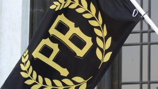A flag with the letters "PB" surrounded by a golden wreath.