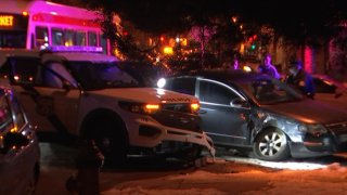 A Philadelphia police SUV rests next to a dark civilian sedan after a crash. Both vehicles have front-end damage.