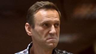 In this Feb. 20, 2021, file photo, Russian opposition leader Alexei Navalny stands inside a glass cell during a court hearing at the Babushkinsky district court in Moscow.