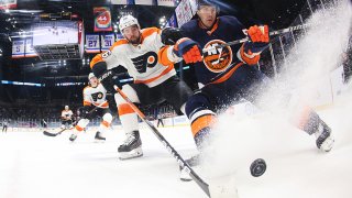 The Flyers and Islanders fight over the puck