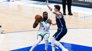 Boston Celtics guard Jaylen Brown (7) makes a move toward the basket as Dallas Mavericks guard Luka Doncic (77) defends during the first half of an NBA basketball game in Dallas, Tuesday, Feb. 23, 2021.