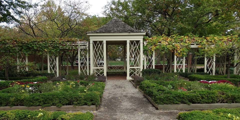 A walkway surrounded on both sides by green plants leads to a gazebo at the 18th century garden in Philadelphia's Independence Hall