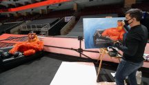 Gritty poses for a painting as an artist paints the Flyers mascot