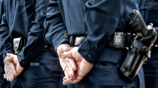 Officers standing with hands behind their backs.