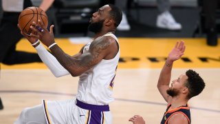 LOS ANGELES, CALIFORNIA - FEBRUARY 28: LeBron James #23 of the Los Angeles Lakers scores on a layup past Stephen Curry #30 of the Golden State Warriors during the second quarter at Staples Center on February 28, 2021 in Los Angeles, California.