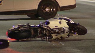 A motorcycle rests on its side on the pavement after a deadly crash in Philadelphia's West Oak Lane neighborhood.