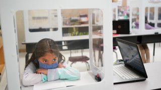 Second grader Londyn Vargas does her school work at Christa McAuliffe School in Jersey City, New Jersey, Thursday, April 29, 2021. Kindergarten through third grade students are returning to their school buildings in Jersey City for their first time in over a year.